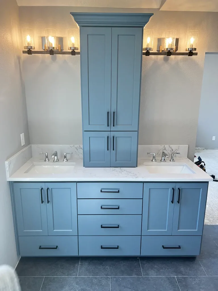 Lighting fixtures in a modern bathroom remodel with blue-grey cabinets